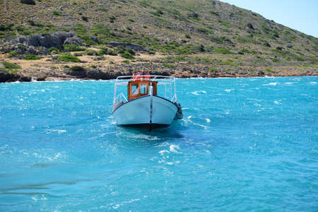 The motor yacht for tourists transportation is near Spinalonga island, Spinalonga, Greece.