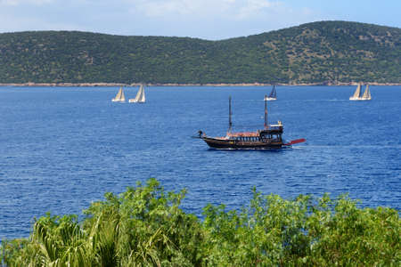The recreation yacht with tourists is near beach of luxury hotel, Bodrum, Turkeyの写真素材