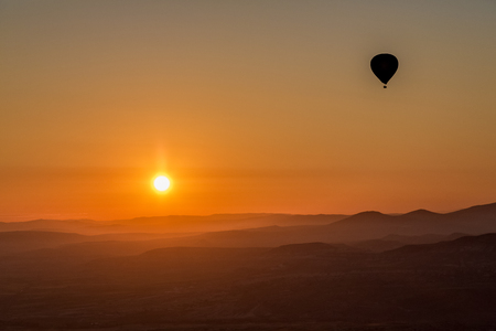 Hot air balloon flying over spectacular Cappadociaの写真素材
