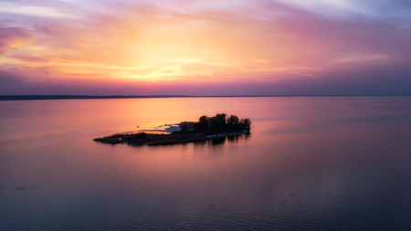Beautiful pink sunset with sun rays over sea.の写真素材