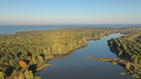 Beautiful river flowing along the forest shooting from a birds eye viewの写真素材
