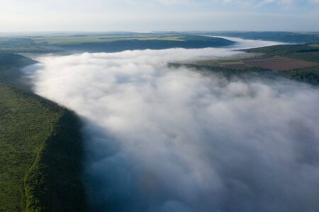 Canyon river in fog shooting from the airの写真素材