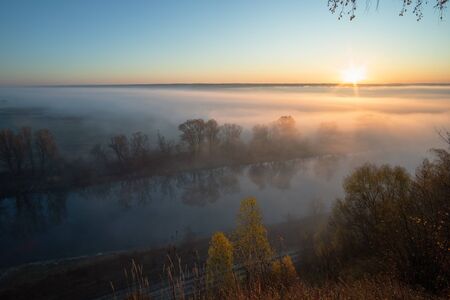 Fantastic foggy river with fresh green grass in the sunlight. Sun beams through tree. Dramatic colorful scenery. Seret river, Ternopil. Ukraine, Europe. Beauty world.の写真素材