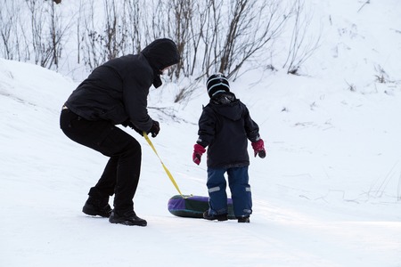 Father and son on a snowy hillの写真素材