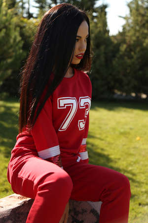 fashion outdoor photo of beautiful sensual woman with long dark hair wears casual clothes, posing in...