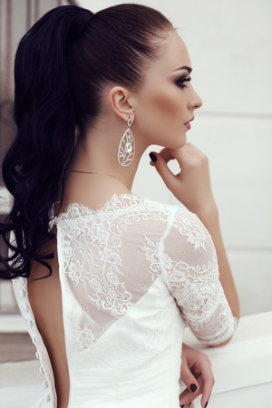 fashion outdoor photo of gorgeous young woman with long dark hair in luxurious lace wedding dressの写真素材