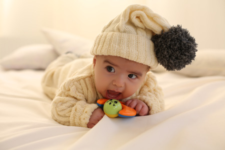 tender family photo of little cute baby boy, wears knitted clothes,having fun at cozy home