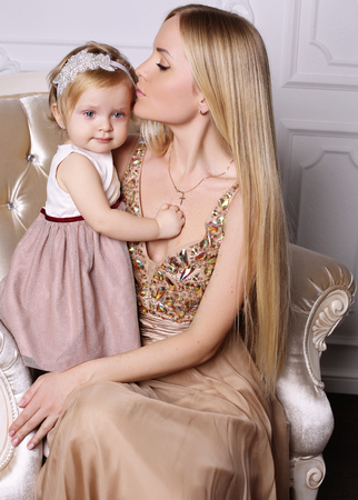 holiday photo of beautiful family. Gorgeous mother with long blond hair posing with adorable cute daughterの写真素材
