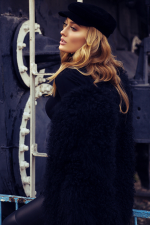 fashion outdoor portrait of beautiful girl with blond curly hair and evening makeup in elegant clothesの写真素材