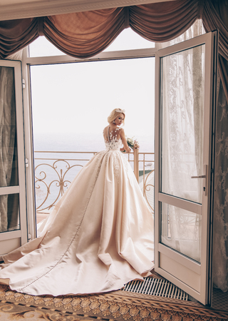 fashion interior photo of beautiful sensual woman with blond hair in luxurious wedding dress and accessoriesの写真素材