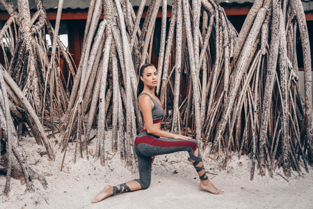 fashion photo of beautiful woman with dark hair in sport suit relaxing on Maldive islandsの写真素材