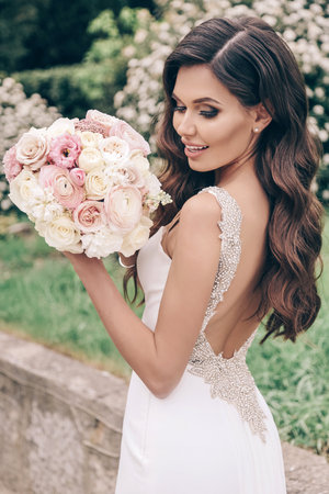 beautiful woman in luxurious wedding dress with tender wedding bouquetの写真素材