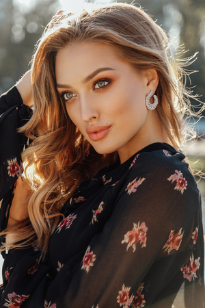 fashion outdoor photo of beautiful woman with blond hair in elegant outfit posing in autumn parkの写真素材