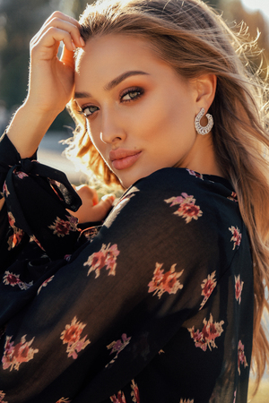 fashion outdoor photo of beautiful woman with blond hair in elegant outfit posing in autumn parkの写真素材