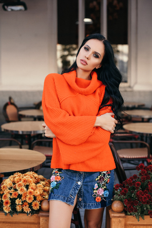 fashion outdoor photo of beautiful woman with dark hair in elegant clothes posing on the streetの写真素材