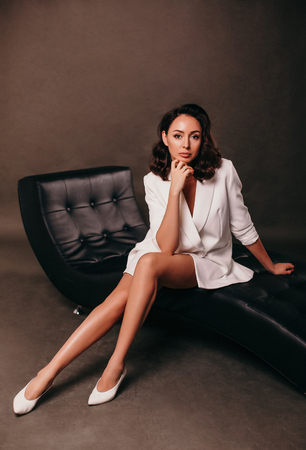 fashion interior photo of businesslike woman with dark hair in elegant office clothesの写真素材