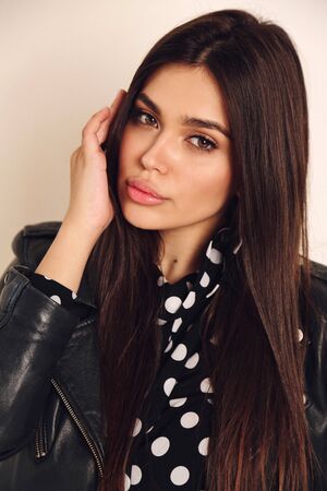 fashion studio photo of beautiful woman with dark hair in elegant dress with accessories