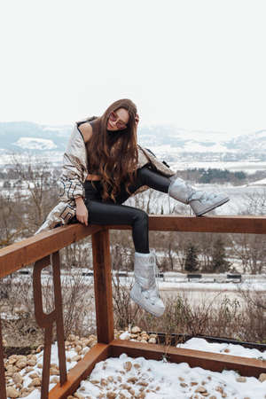 fashion outdoor photo of beautiful woman with dark hair in elegant warm clothes posing in winter...