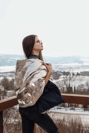 fashion outdoor photo of beautiful woman with dark hair in elegant warm clothes posing in winter...