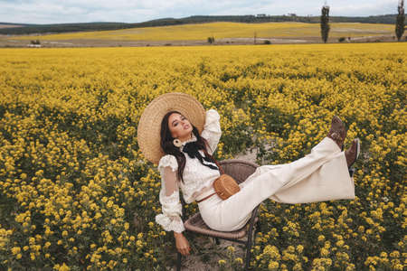 fashion outdoor photo of beautiful woman with dark hair in elegant clothes and hat posing in...