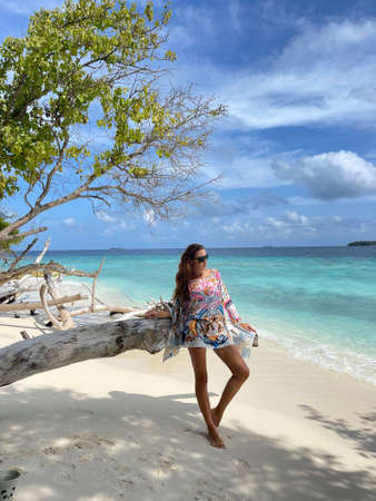 fashion photo of beautiful woman in beach clothes posing on the tropical beach in Maldivesの写真素材