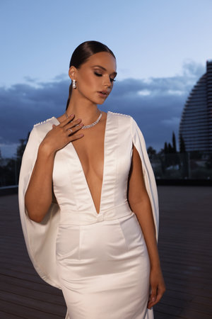 fashion photo of beautiful bride in elegant wedding dress and accessories posing outdoorの写真素材