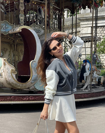 fashion outdoor photo of beautiful woman with dark hair in casual clothes posing on Montmartre near carouselの写真素材