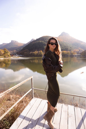 fashion outdoor photo of beautiful slavic woman with dark hair in elegant dress posing among beautiful natureの写真素材