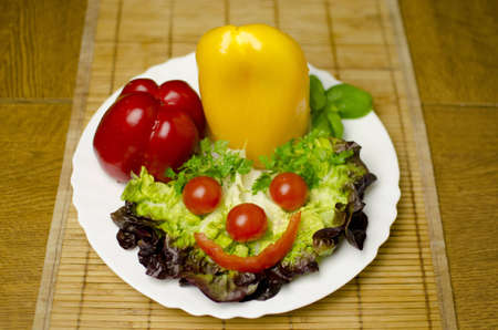 Tomatoes, peppers, salad are well decorated on a white plate. Shallow depth of the field.の写真素材