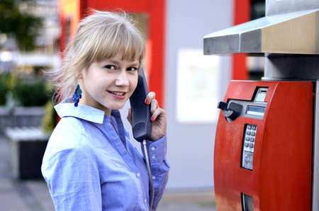 A beautiful young girl is waiting for a call and has picked up the phone.