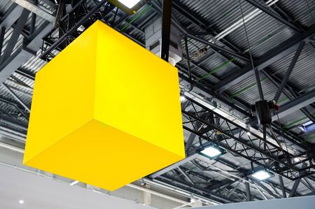 yellow glowing cube suspended under the roof of the hangarの写真素材