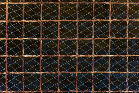 fencing made of rusty lattice and meshの写真素材