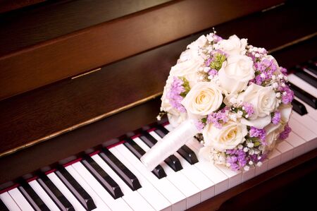 brides bouquet lies on the piano keyboard close-upの写真素材