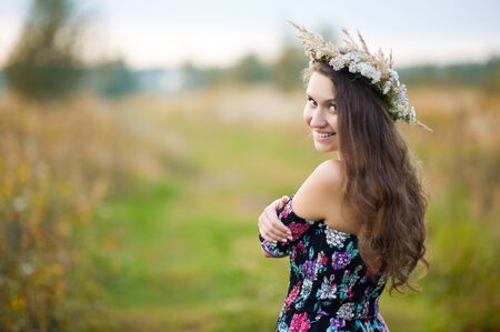 close-up portrait of a girl in a colorful dress with patterns that smiles at the cameraの写真素材