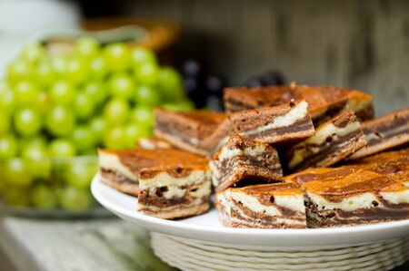 a plate with pieces of cake and in the background a plate with grapes