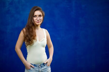 girl with glasses on a background of blue textured wallの写真素材
