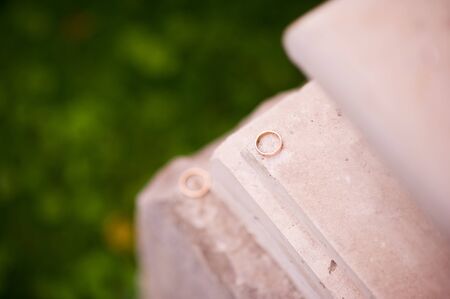 one wedding ring lies on the ledge of the wall and against the background of it lies the second ringの写真素材