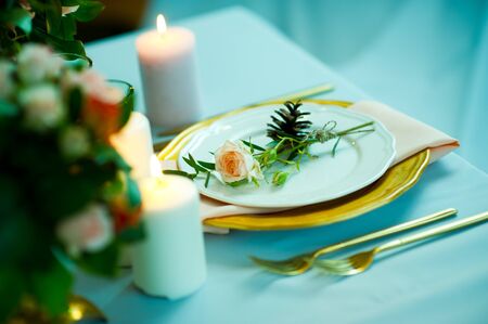 turquoise-colored table with gold plates and cutleryの写真素材