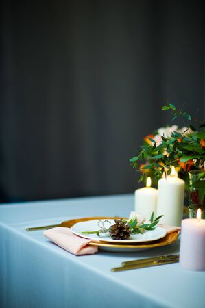 turquoise-colored table with gold plates and cutleryの写真素材
