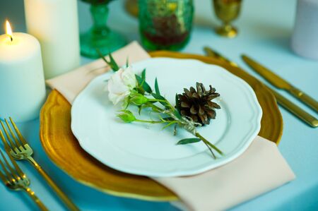 turquoise-colored table with gold plates and cutleryの写真素材