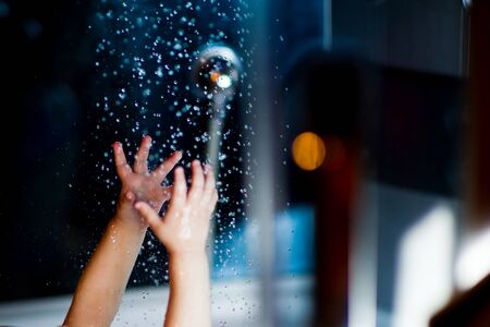 hands of a small child reach for water close-upの写真素材