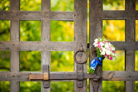 the bride s bouquet is stuck in the handle of the antique collar of the old church. Close-up, selective focusの写真素材