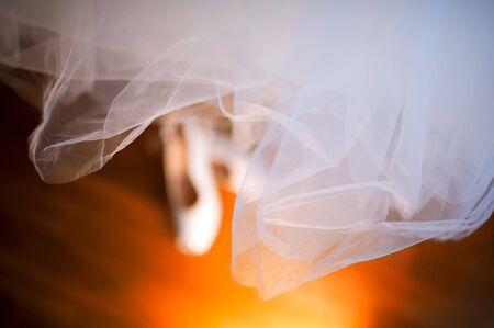 shoes of the bride stand on a wooden floor, top view. Bridesmaid dress hanging over the shoesの写真素材