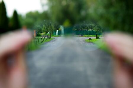 look through glasses on a rustic view. Oblique fences, forest, grass are clearly visible through the...