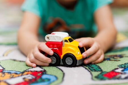 child plays with a toy car. Focus on hand and toyの写真素材
