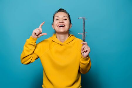 the girl laughs out loud, showing a small size with a caliper and fingers