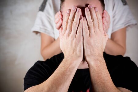 the girl covers her ears with the palms of the man, and the man covers his face, close up