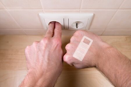 a man is charging from a household outlet by inserting fingers into it. Charge indicator on second...
