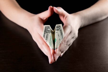 girl holding a plane from a one dollar bill, close upの写真素材