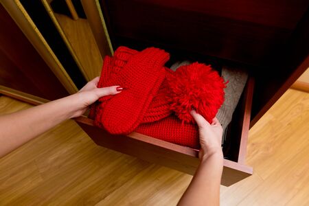 girl takes a set of warm winter accessories from a box, close upの写真素材